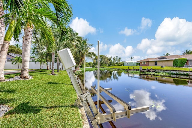 view of dock with a water view and a lawn