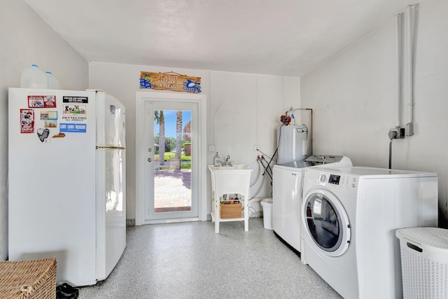 clothes washing area featuring washing machine and dryer and water heater