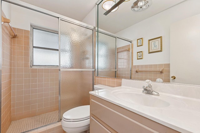 bathroom with toilet, a shower with shower door, tile walls, and vanity