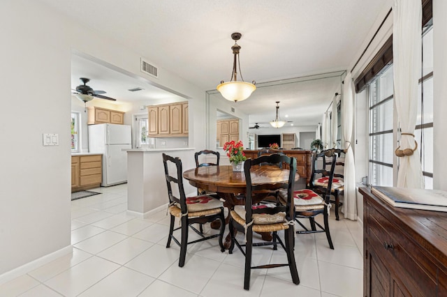 tiled dining room featuring a textured ceiling and ceiling fan