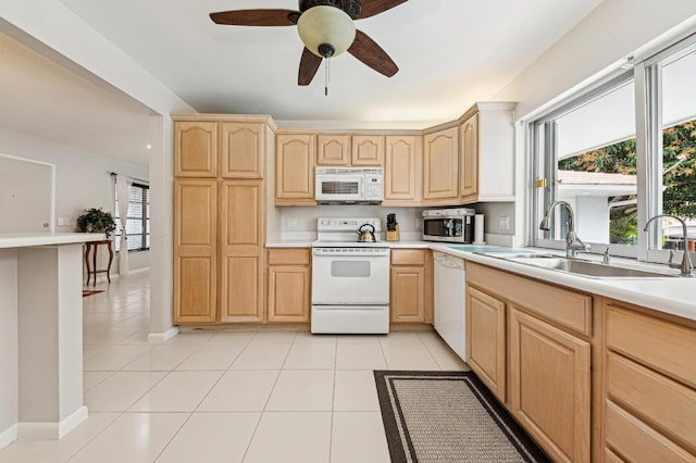 kitchen with white appliances, light tile patterned floors, light brown cabinetry, plenty of natural light, and sink