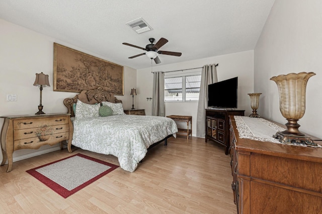 bedroom featuring a textured ceiling, ceiling fan, and light hardwood / wood-style flooring