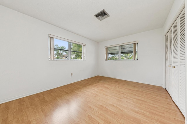 unfurnished bedroom with a closet and light hardwood / wood-style floors