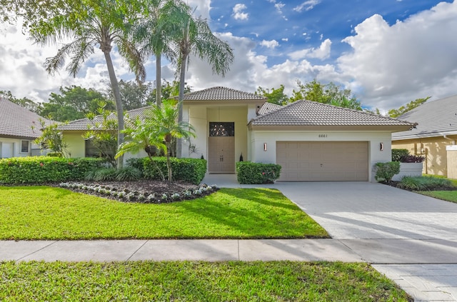 mediterranean / spanish-style home featuring a front yard and a garage