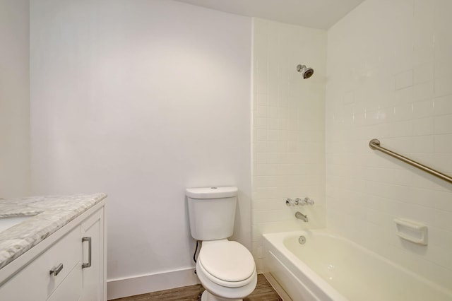 full bathroom featuring vanity, wood-type flooring, tiled shower / bath combo, and toilet