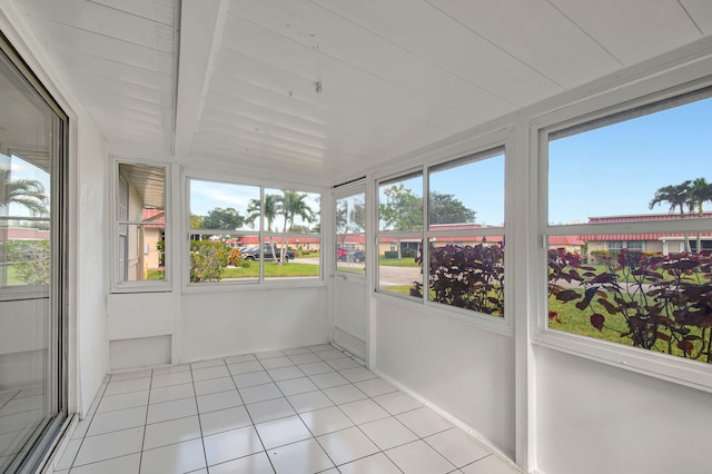 unfurnished sunroom featuring beamed ceiling