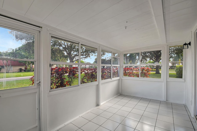 unfurnished sunroom featuring beam ceiling