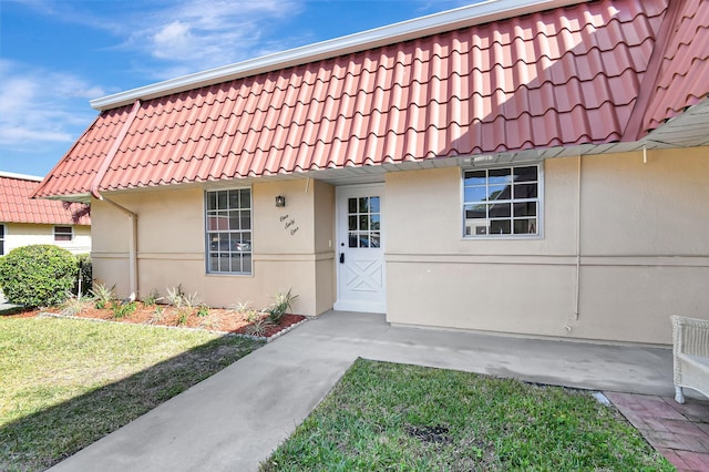 property entrance with a lawn