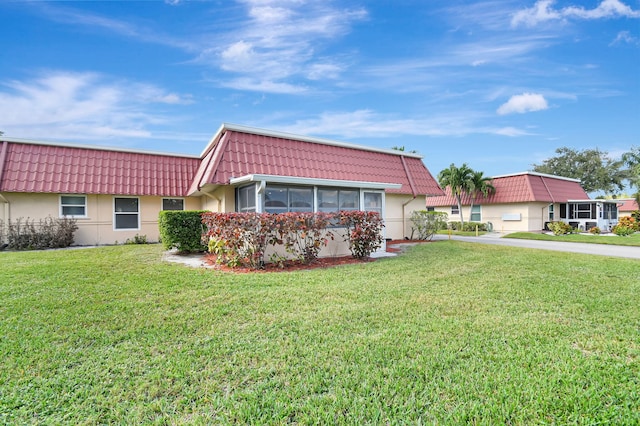 single story home featuring a front lawn and a sunroom