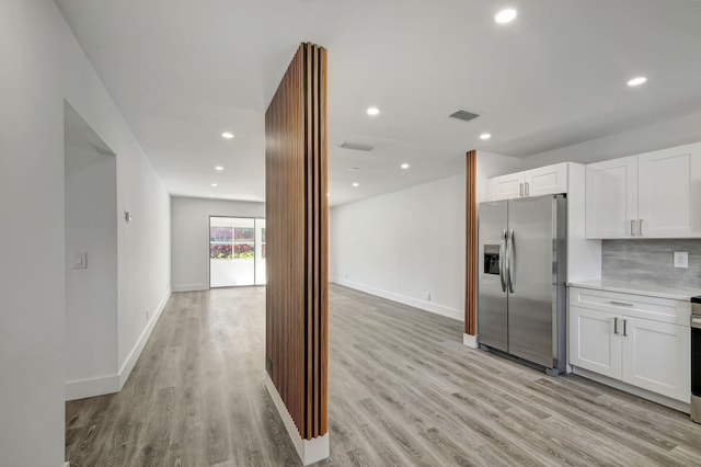 kitchen with decorative backsplash, white cabinets, light hardwood / wood-style floors, and stainless steel refrigerator with ice dispenser