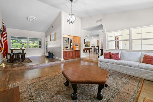 living room with hardwood / wood-style flooring, high vaulted ceiling, and a notable chandelier