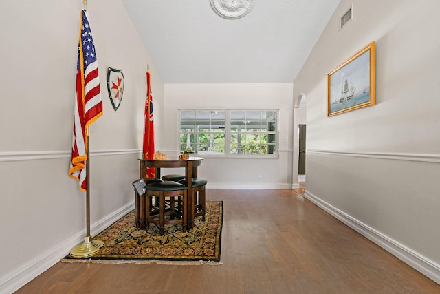 hallway with hardwood / wood-style floors and lofted ceiling