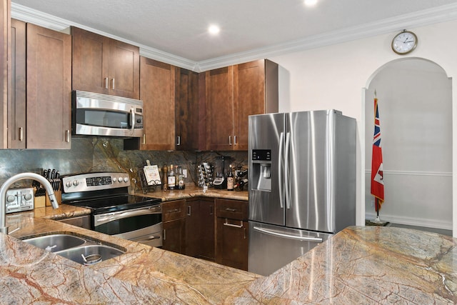 kitchen featuring light stone countertops, appliances with stainless steel finishes, backsplash, crown molding, and sink