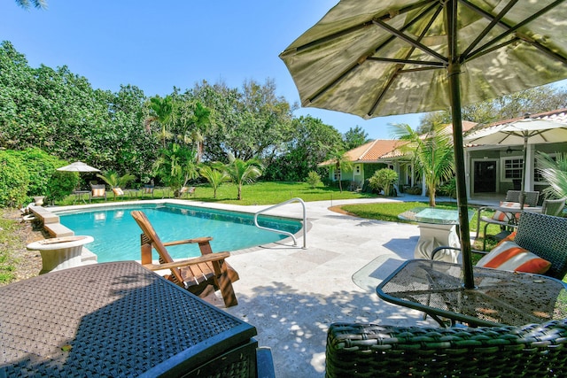 view of swimming pool featuring a yard and a patio