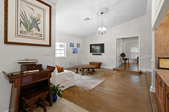 interior space with hardwood / wood-style flooring, lofted ceiling, and a notable chandelier