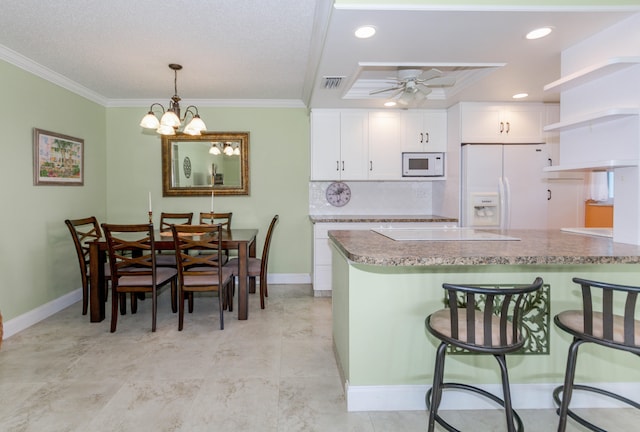 kitchen featuring a breakfast bar area, kitchen peninsula, white cabinetry, and white appliances