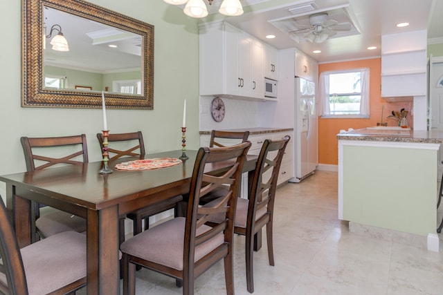 dining room with ceiling fan and ornamental molding