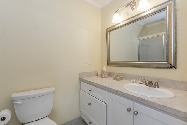 bathroom with crown molding, vanity, a shower with shower door, and toilet