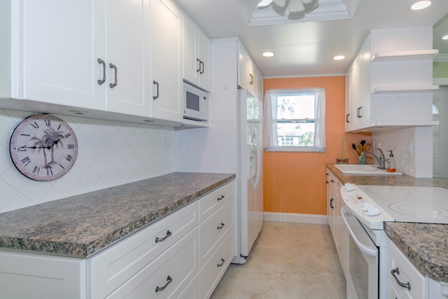 kitchen featuring white cabinets, decorative backsplash, white appliances, and sink