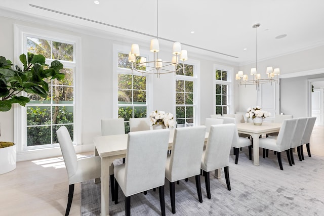 dining room featuring a notable chandelier, light hardwood / wood-style floors, and ornamental molding