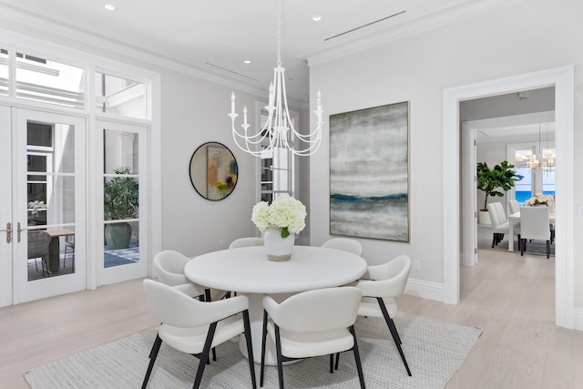 dining room featuring crown molding, a notable chandelier, and light wood-type flooring