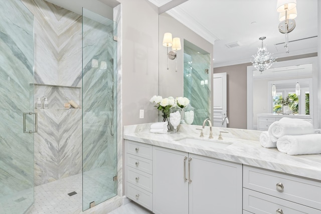 bathroom with an inviting chandelier, vanity, a shower with shower door, and ornamental molding