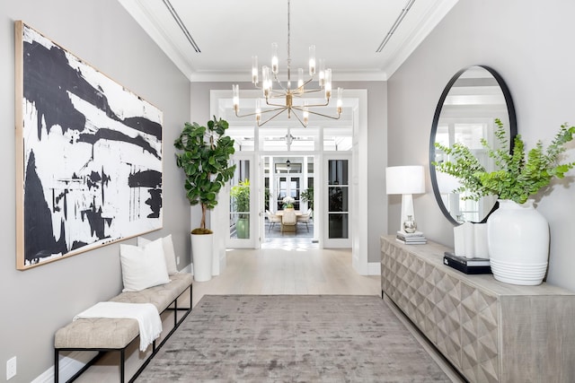 interior space with french doors, hardwood / wood-style flooring, an inviting chandelier, and crown molding