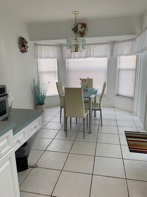 dining room featuring an inviting chandelier, a healthy amount of sunlight, and light tile patterned flooring