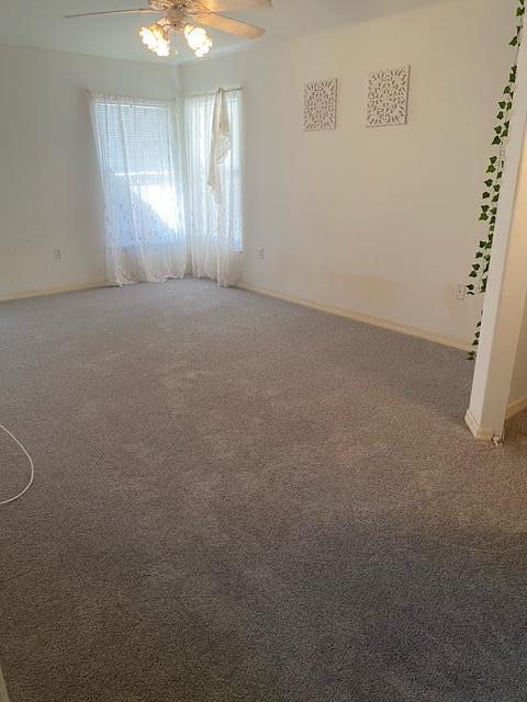 carpeted spare room with ceiling fan