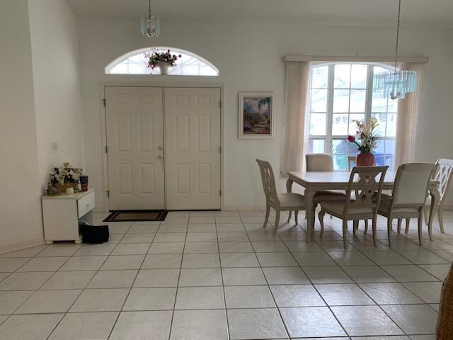 foyer featuring plenty of natural light, light tile patterned floors, and a notable chandelier