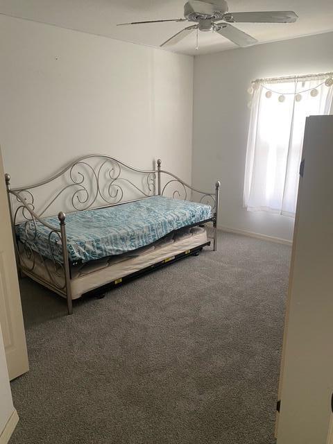 bedroom featuring dark colored carpet and ceiling fan