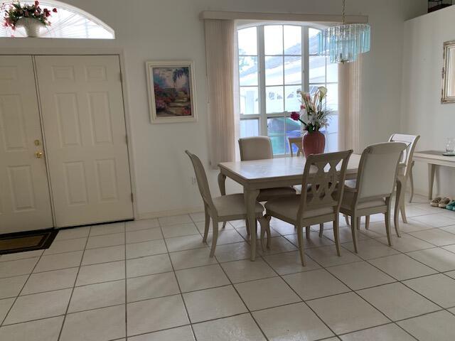 tiled dining room with a chandelier