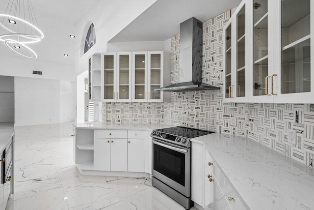 kitchen with backsplash, stainless steel electric stove, wall chimney range hood, decorative light fixtures, and white cabinetry