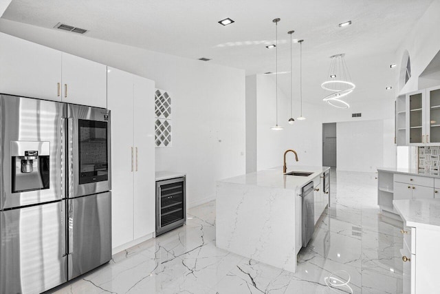 kitchen featuring a large island, hanging light fixtures, wine cooler, white cabinets, and appliances with stainless steel finishes