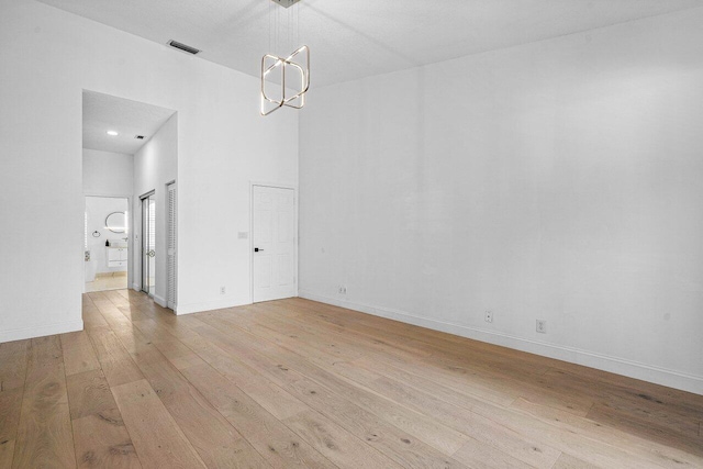 unfurnished dining area featuring light hardwood / wood-style floors and a chandelier