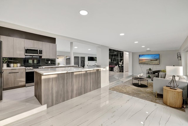 kitchen with decorative backsplash, stainless steel appliances, a spacious island, and sink