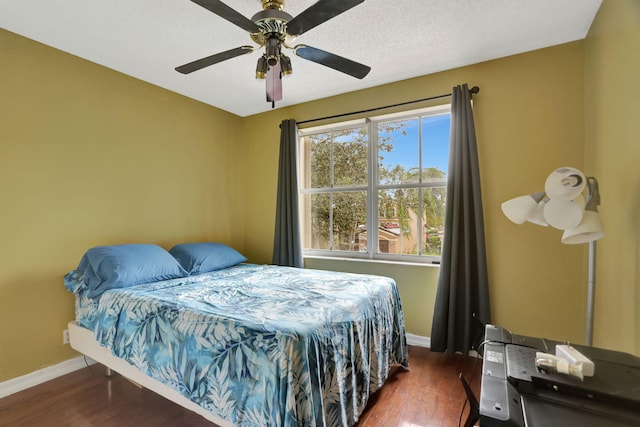 bedroom featuring a textured ceiling, ceiling fan, and dark wood-type flooring