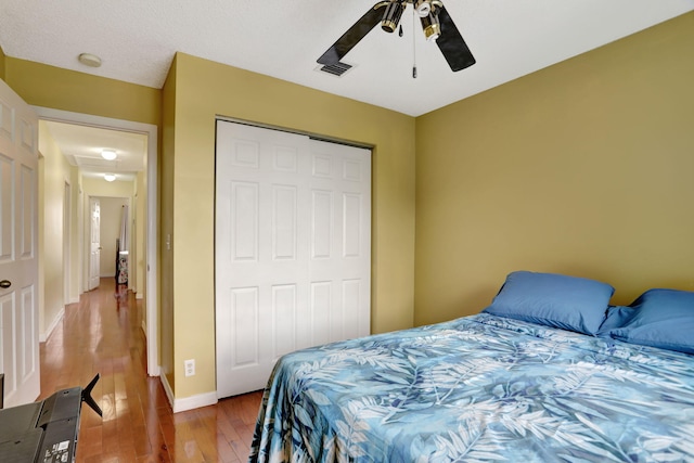 bedroom with wood-type flooring, a closet, and ceiling fan