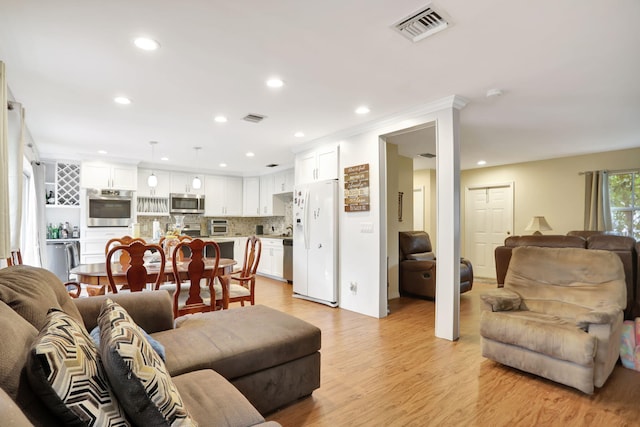 living room with light hardwood / wood-style floors and crown molding