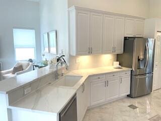 kitchen featuring kitchen peninsula, white cabinetry, sink, and appliances with stainless steel finishes