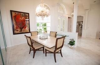 dining area featuring a towering ceiling and a notable chandelier