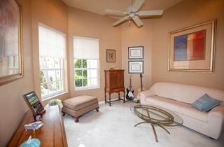 living area featuring carpet and ceiling fan