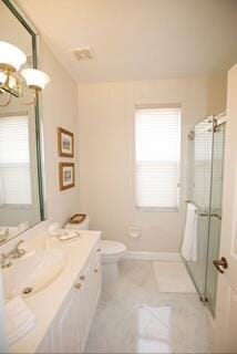 bathroom featuring an inviting chandelier, tile patterned flooring, toilet, a shower with door, and vanity