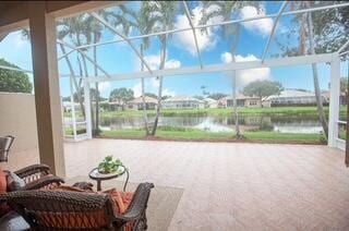 view of patio featuring a water view and a lanai