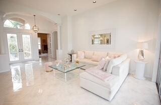 living room featuring lofted ceiling and french doors