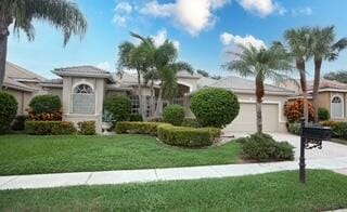 view of front of property featuring a front lawn and a garage