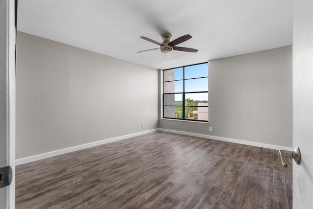 spare room with dark hardwood / wood-style flooring and ceiling fan