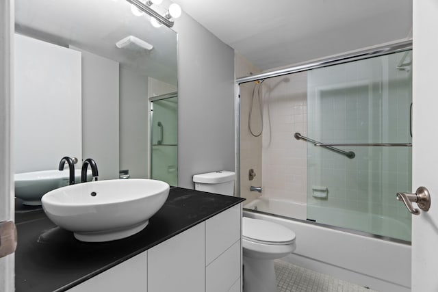 full bathroom featuring tile patterned flooring, vanity, toilet, and enclosed tub / shower combo