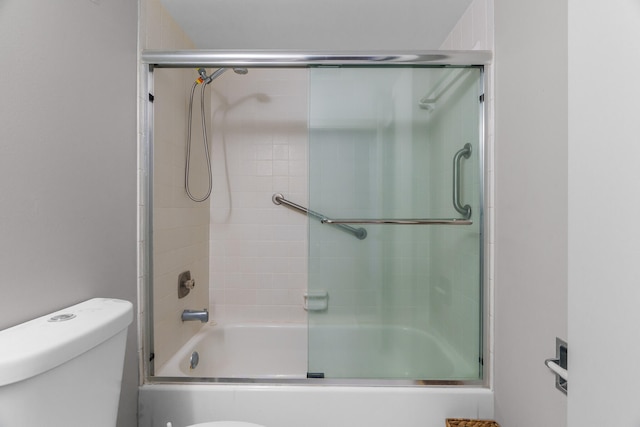 bathroom featuring shower / bath combination with glass door and toilet