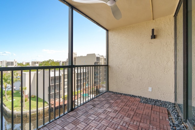 balcony with ceiling fan and a water view